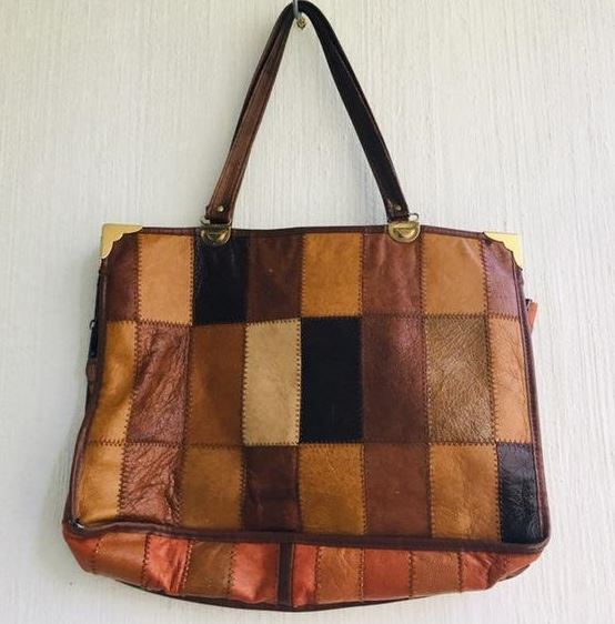 A colour photograph of a leather patchwork tote bag.