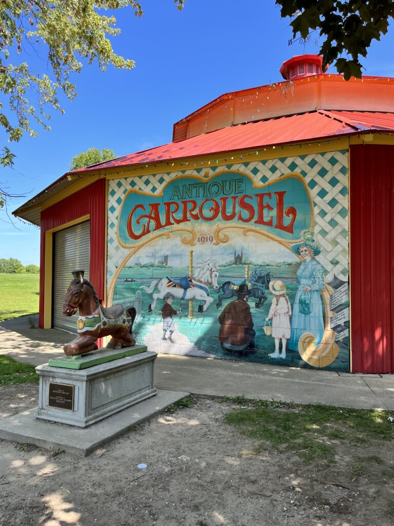 Bright red Carousel building with an old-timey mural on the side