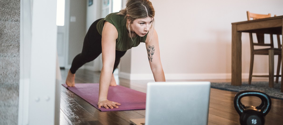 Woman working out at home with an online fitness program.