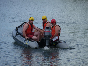 Water rescue 3 fire men heading out onto the water in a motorized dinghy