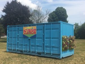 A reused shipping container painted blue and filled with activities for kids