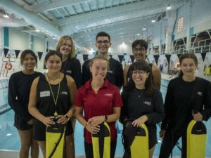 Lifeguards standing in front of an indoor pool