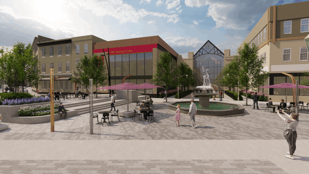 Street-level view of a modern urban plaza during the day. The space features a central fountain, purple shade umbrellas over seating areas, and landscaped planters with greenery. A large red heart sculpture stands near the left side, and people are walking, cycling, and sitting at tables. Surrounding buildings include a glass atrium and a bank with a red sign reading “CIBC Banking Centre.” Traffic lights and wide pedestrian walkways are visible.