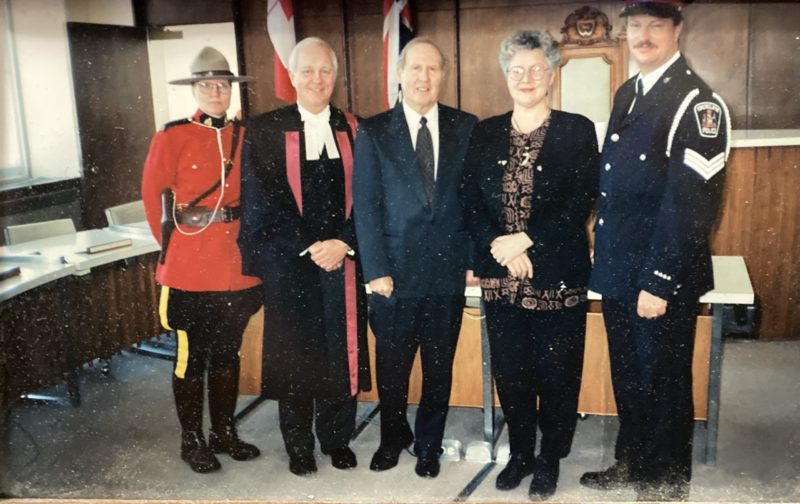 A colour photograph of five individuals dressed for a special occasion. One wears a Mountie uniform.