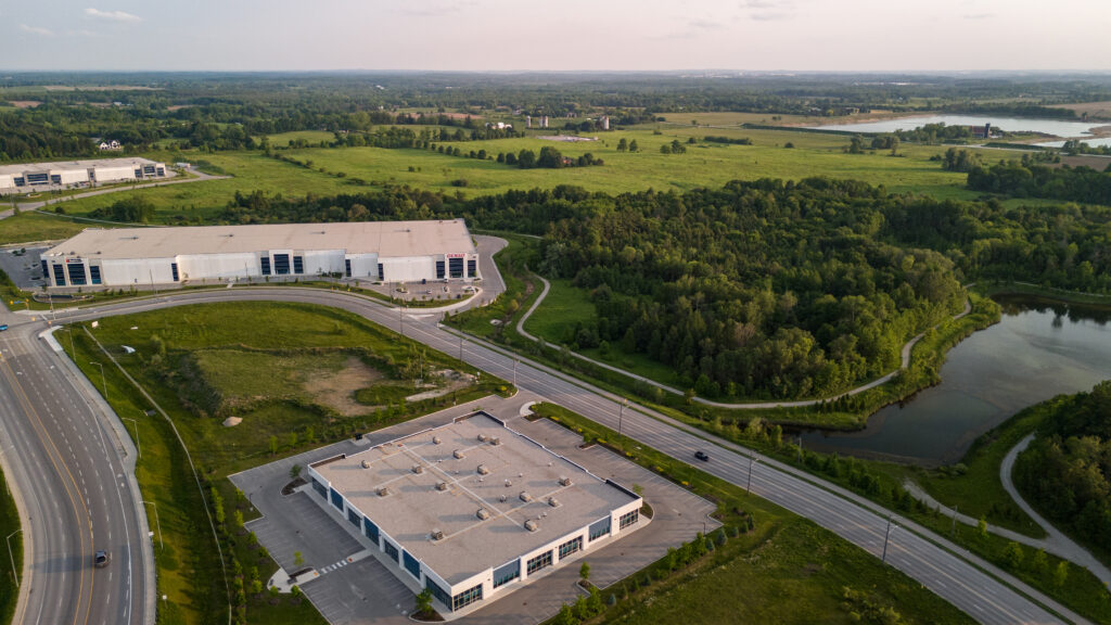 Aerial view of a land showing a property on site and green fields 