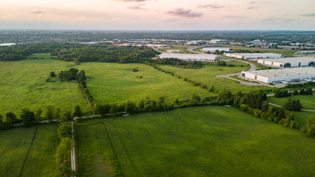 Aerial view on green field featuring a property on site