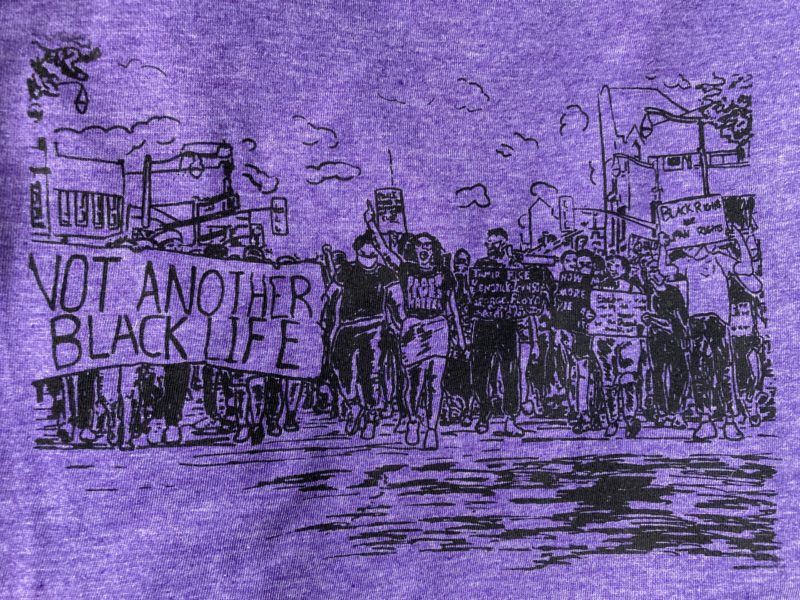 A photo of the drawing above silkscreened onto a purple t-shirt.