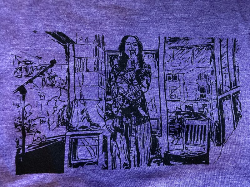 A photo of the drawing above silkscreened onto a purple t-shirt