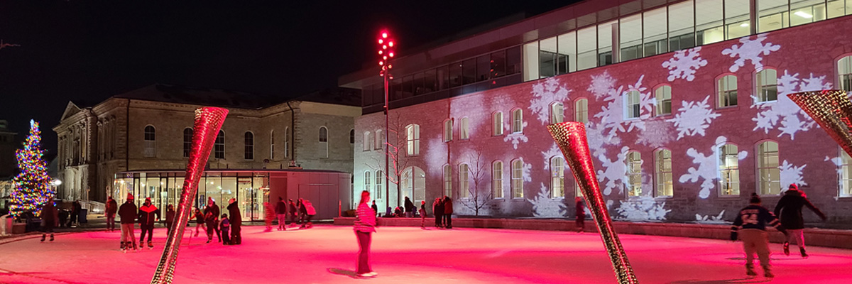 SparkleSquare by Jen Rafter. Market Square skating rink with red lighting and snowflakes projected on the wall of City Hall