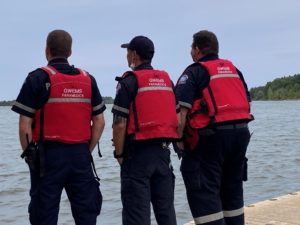 Paramedics standing in front a lake