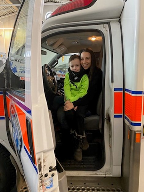 woman and child sitting in the front seat of an ambulance