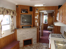 Safety Trailer living room Living room of the safety trailer, featuring the fireplace, television, stove and sink
