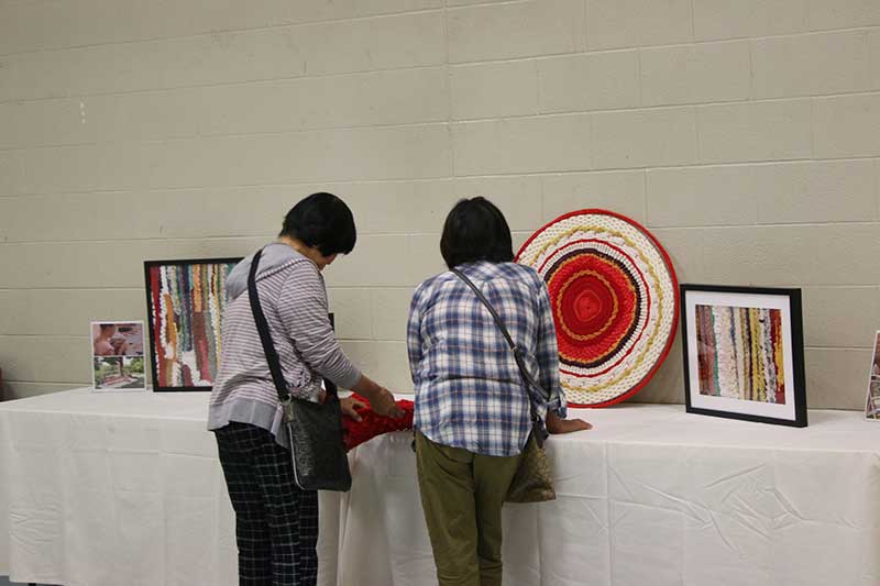 people looking at weavings