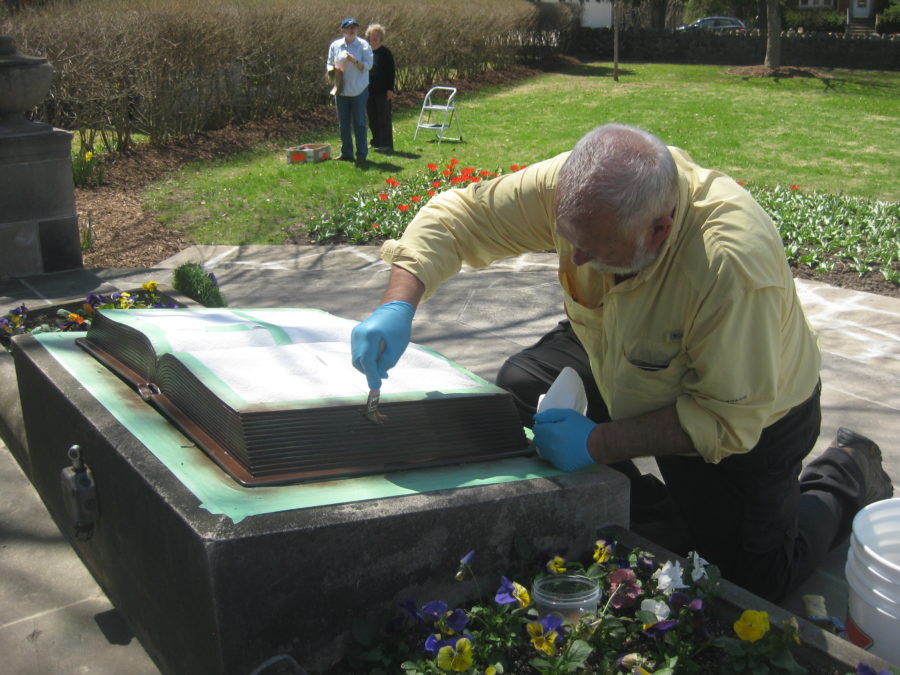 Craig Johnson carries out conservation work on the bronze book, the centerpiece of the memorial, 2015