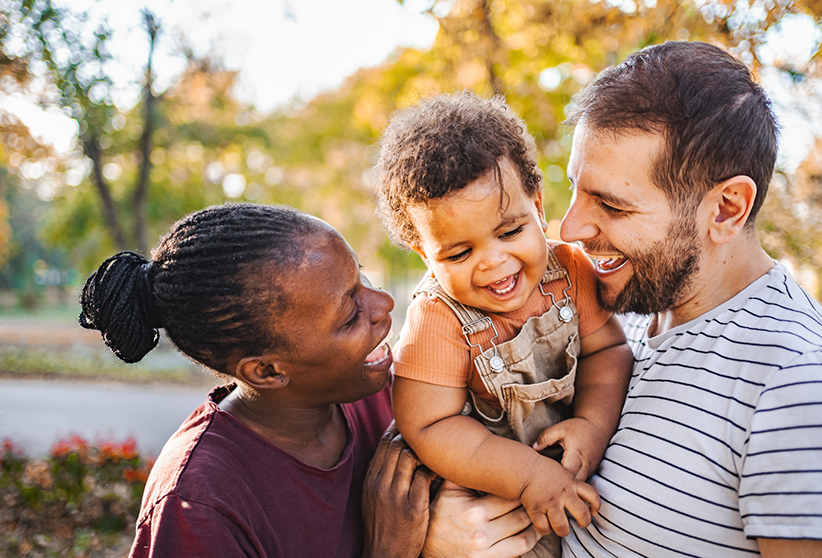 A man and a woman holding a child