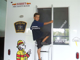 Safety Trailer - Window escape A boy performing a window escape climbing through the window of the trailer