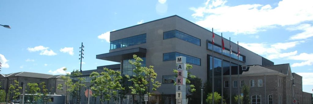 Front section of new City Hall with flag poles and the Market Square sign.