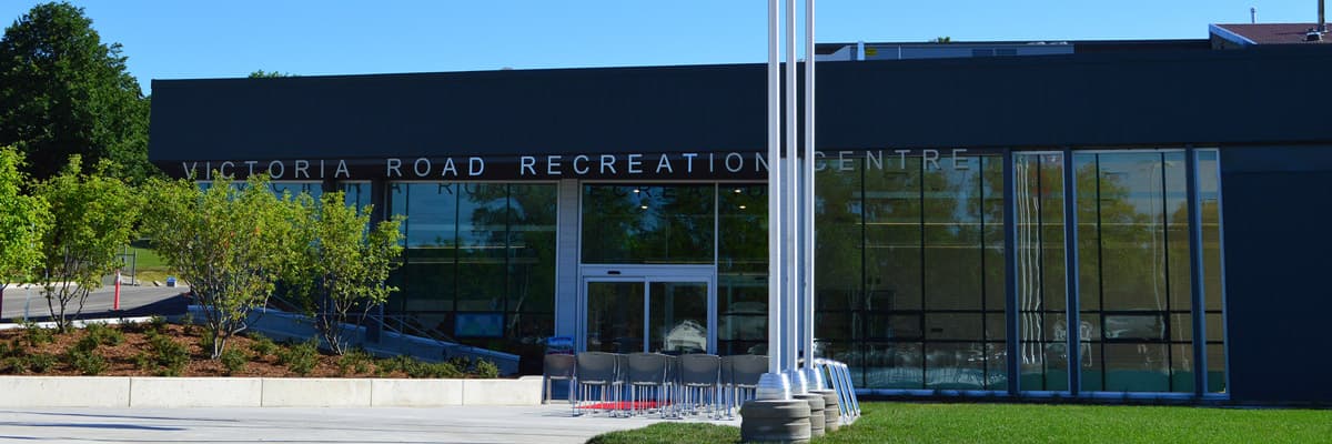 Front entrance to the Victoria Road Recreation Centre with flags and bike racks outside