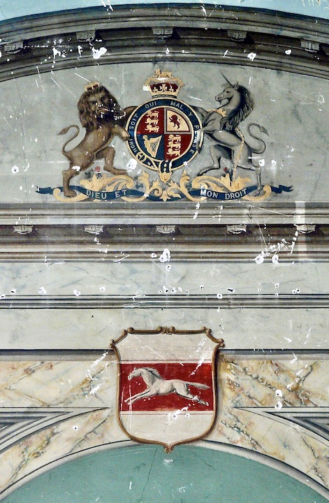 A colour photograph of a coat of arms with a lion and unicorn, and the words, “Dieu et mon droit.”