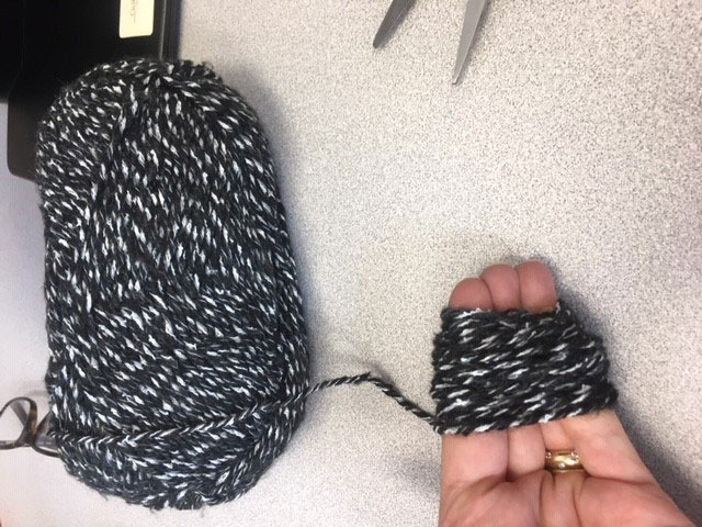 wrapping yarn around hand to make pom pom