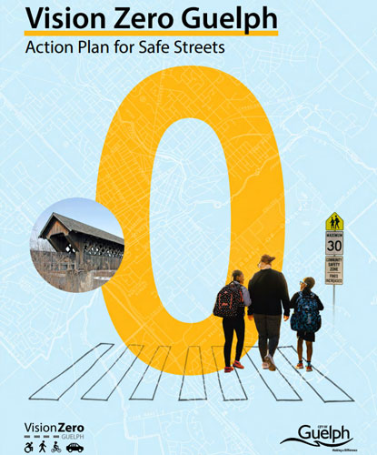 A crosswalk with 3 pedestrians and a giant yellow zero behind them.